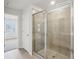 Modern bathroom featuring a glass-enclosed shower with tile surround and a view into an adjacent room at 1230 Firefly Field Trce, Lawrenceville, GA 30045
