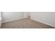Spacious bedroom with plush carpeting, white walls, and a doorway leading to additional living space at 1230 Firefly Field Trce, Lawrenceville, GA 30045