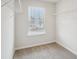 Well-lit walk-in closet with carpet, wire shelving, and a window offering natural light and ventilation at 1230 Firefly Field Trce, Lawrenceville, GA 30045