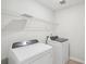 Functional laundry room with modern washer and dryer, and wire shelving for storage at 1230 Firefly Field Trce, Lawrenceville, GA 30045