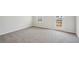 Cozy living area showcasing plush carpeting, a window view and a door leading to the outside at 1230 Firefly Field Trce, Lawrenceville, GA 30045