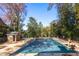 Community pool with cover during the autumn season, surrounded by trees and a brick pool house at 1101 Collier Nw Rd # V6, Atlanta, GA 30318