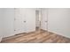 A bedroom features wood-look flooring, fresh white paint and several doors for flexible access at 113 Ambridge Ct, Lawrenceville, GA 30044