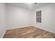 A bright bedroom features a wood-look floor and a window with a view of the trees at 113 Ambridge Ct, Lawrenceville, GA 30044