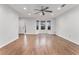 Spacious living room featuring gleaming hardwood floors, a ceiling fan, and bright windows at 113 Ambridge Ct, Lawrenceville, GA 30044