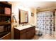 Bathroom with granite vanity, shower with patterned curtain, and storage shelving at 907 Hannah Ct, Loganville, GA 30052