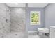 Modern bathroom featuring a marble tiled shower and mosaic tile floor and bright window at 3293 Valleydale Sw Dr, Atlanta, GA 30311