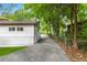 Long driveway running beside a well manicured yard, mature trees and white brick home at 3293 Valleydale Sw Dr, Atlanta, GA 30311