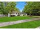 Traditional white brick home featuring a well manicured lawn, mature trees and shrubs at 3293 Valleydale Sw Dr, Atlanta, GA 30311