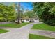 Classic home featuring a brick facade, white trim, mature trees, and a long driveway at 3293 Valleydale Sw Dr, Atlanta, GA 30311