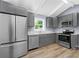 Modern kitchen featuring stainless steel appliances, gray cabinetry, and wood-look flooring at 3293 Valleydale Sw Dr, Atlanta, GA 30311