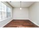 Simple dining area with large window and hardwood floors at 7077 Ravenwood Ln, Lithonia, GA 30038