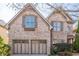 Brick two-story house with three-car garage and mature trees at 129 Janney Cir, Mcdonough, GA 30253