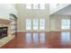 Spacious living room featuring hardwood floors, a stone fireplace, and a high ceiling at 129 Janney Cir, Mcdonough, GA 30253