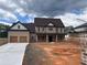 Striking new construction home featuring a brick exterior, covered porch, and an attached two-car garage at 1937 Pucketts Sw Dr, Lilburn, GA 30047
