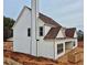 Angle view showing white siding, a classic chimney and well-lit windows on this home at 1937 Pucketts Sw Dr, Lilburn, GA 30047