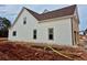 Side elevation of new home showing the white vinyl siding, dark trim, and lush lawn at 1937 Pucketts Sw Dr, Lilburn, GA 30047