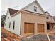 View of the attached garage and side elevation, with brick and shingle details on this new home at 1937 Pucketts Sw Dr, Lilburn, GA 30047
