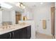 Bright bathroom with a double sink vanity, large mirrors, updated lighting, and a tile shower-tub combo at 1827 Rockridge Pl, Atlanta, GA 30324