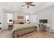 Spacious main bedroom with a tray ceiling, a ceiling fan, plush carpet, a desk, and two windows at 1827 Rockridge Pl, Atlanta, GA 30324