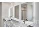 Bathroom featuring double sinks with illuminated mirrors and granite countertops, a modern design at 1586 Sungrown Way, Mcdonough, GA 30253