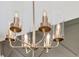 Close up of a modern gold chandelier with glass shades and decorative bulbs at 1586 Sungrown Way, Mcdonough, GA 30253