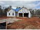 Exterior view of new construction showcasing the home's framing, wrapped with protective material and a blue-covered roof at 1586 Sungrown Way, Mcdonough, GA 30253