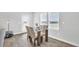 Bright dining area featuring a glass-top table, modern chairs, and natural light from large windows at 1586 Sungrown Way, Mcdonough, GA 30253