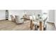 Open-concept living room with dining area, modern furniture, and wood-look floors at 1586 Sungrown Way, Mcdonough, GA 30253