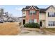 Two-story townhouse with brick and vinyl siding, a covered front porch, and mature landscaping at 1450 Riverrock Trl, Riverdale, GA 30296
