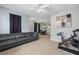 Spacious living room with open concept floor plan, neutral carpeting, and black out curtains and modern lighting at 1450 Riverrock Trl, Riverdale, GA 30296