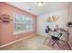 Home office with pink walls, a large window, and desk space for remote work at 1450 Riverrock Trl, Riverdale, GA 30296