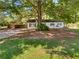 View of the home with a mature shade tree and a carport at 30 N Cleveland Church Rd, Mcdonough, GA 30253