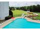 View of a long water slide and adjacent community pool, with green space and trees in the background at 631 Egrets Lot 50 Lndg, Covington, GA 30014