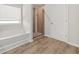 Bathroom featuring a glass-enclosed shower with tile surround, tub, and wood-look flooring at 3372 Baylor Cir, Mcdonough, GA 30253