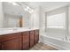 Bright bathroom featuring a soaking tub, double vanity with dark cabinets, and a large mirror at 3372 Baylor Cir, Mcdonough, GA 30253