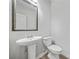 Small half bathroom features pedestal sink, toilet and framed mirror at 3372 Baylor Cir, Mcdonough, GA 30253