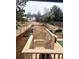 Spacious fenced backyard with tiered deck, garden beds, and well-maintained lawn and stairs at 2961 Rolling Ln, Winston, GA 30187