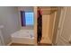 Bright bathroom with a soaking tub, tiled shower, and a window with privacy glass at 2961 Rolling Ln, Winston, GA 30187