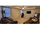 Spacious living room with brown sofas, a ceiling fan, and a dedicated work area with a desk at 2961 Rolling Ln, Winston, GA 30187