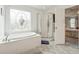 Bathroom with garden tub, shower, and stained glass window at 3825 Green Ave, Loganville, GA 30052