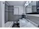 Bathroom featuring grey-tone tile, updated vanity, shower/tub combo and large mirror at 3479 Chestnut Dr, Atlanta, GA 30340