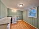 Bright laundry room featuring wood paneling, updated light fixture and white utility sink at 3479 Chestnut Dr, Atlanta, GA 30340