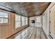 Cozy sunroom featuring wood-look floors, wood paneled ceiling, multiple windows, and a modern fireplace at 3479 Chestnut Dr, Atlanta, GA 30340