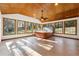 Sunroom with a hot tub and vaulted ceiling, featuring large windows and tile flooring at 3562 Ontario Ct, Buford, GA 30519