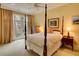 Cozy bedroom with a four-poster bed, neutral carpet, balcony access, and warm lighting for a relaxing ambiance at 1 Brookhaven Ne Dr # 301, Atlanta, GA 30319