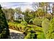 Exterior view of a white home surrounded by lush landscaping, trees, and manicured grounds at 1 Brookhaven Ne Dr # 301, Atlanta, GA 30319