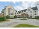 Low-angle view of an elegant multi-story home with concrete driveway, manicured landscaping, and blue sky at 1 Brookhaven Ne Dr # 301, Atlanta, GA 30319