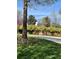Exterior view of a house with a yard, trees, and yellow flower beds next to a tree and a road at 1 Brookhaven Ne Dr # 301, Atlanta, GA 30319