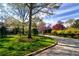 Scenic front yard with colorful flowers, lush greenery, and a driveway under a clear sky at 1 Brookhaven Ne Dr # 301, Atlanta, GA 30319